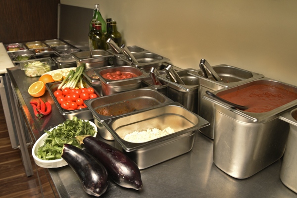 Frisches Buffet mit buntem Gemüse wie Auberginen, Tomaten, Kräutern und Saucen