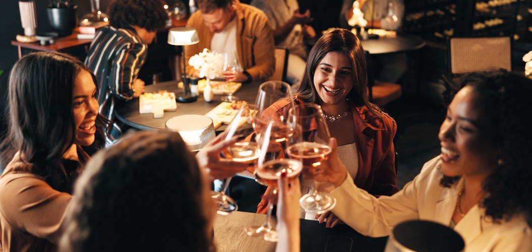 Glückliche Frauen, Freunde und eine Nacht mit Jubel im Restaurant zur Feier, zum Anstoßen oder zum Beisammensein. Frauen, Gruppe oder Abendausflug mit Weingläsern, Getränken oder Alkohol für gesellschaftliche Zusammenkünfte oder Veranstaltungen.